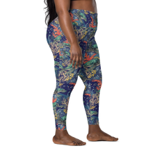 Load image into Gallery viewer, A side-profile view of a scuba diver wearing high-waisted leggings with a vibrant, multicolored underwater coral reef pattern on a dark navy blue background.