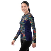 Load image into Gallery viewer, A woman modeling a long-sleeve rash guard with a navy blue base and a colorful underwater coral reef print on the sleeves and front.